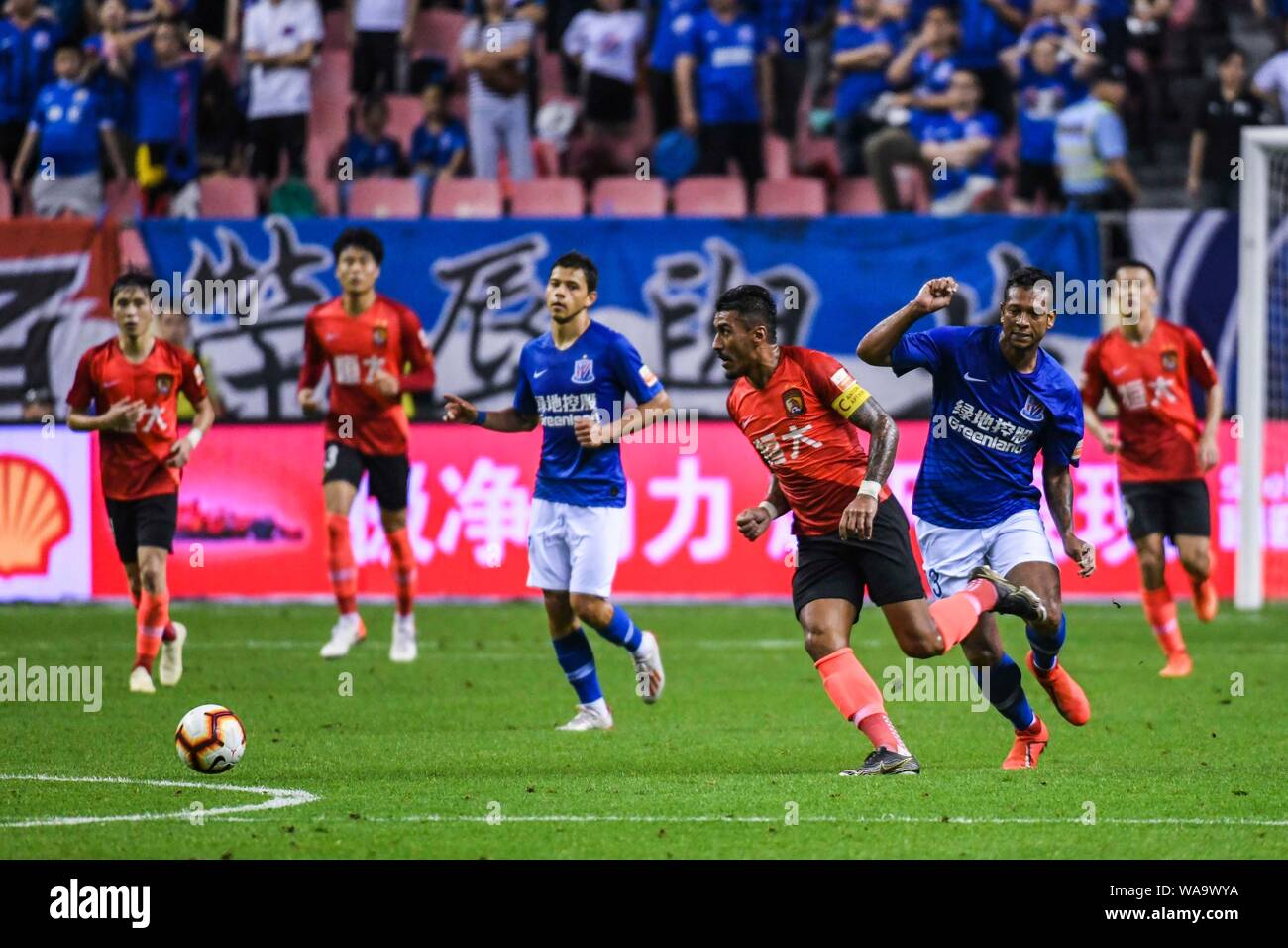 Brazilian football player Paulinho, center, of Guangzhou Evergrande Taobao passes the ball against Colombian football player Fredy Guarin of Shanghai Stock Photo