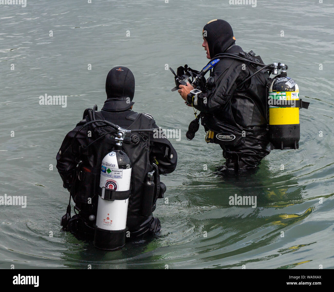 Scuba divers or sub aqua divers standing in the water Stock Photo