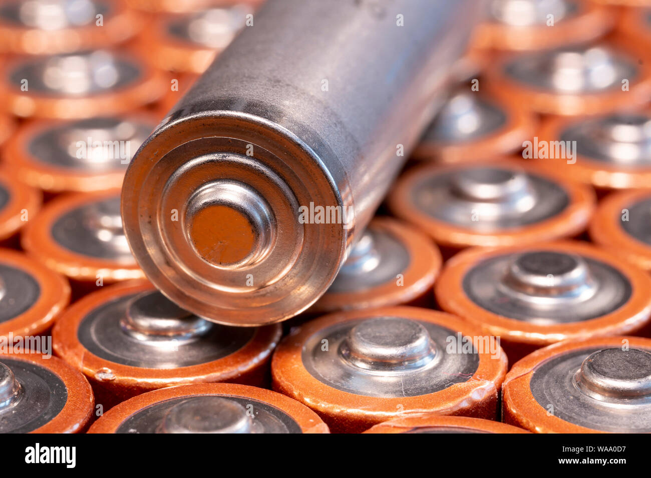 Multiple used AA alkaline batteries are seen arranged in a pile