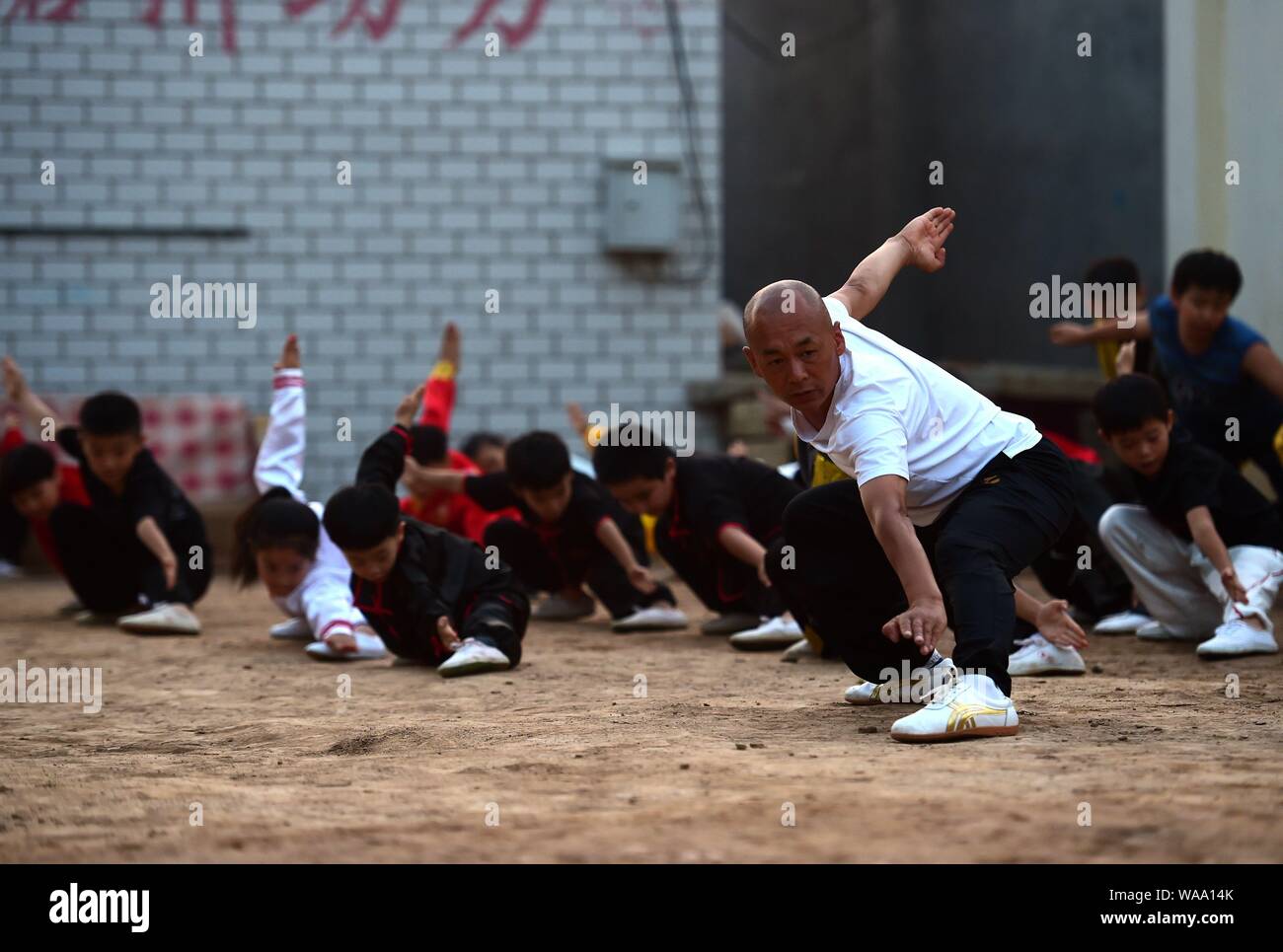 A Chinese child practices Chinese martial arts or kungfu directed by Chen Honglin, a well-known local practitioner, to maintain fitness during the sum Stock Photo