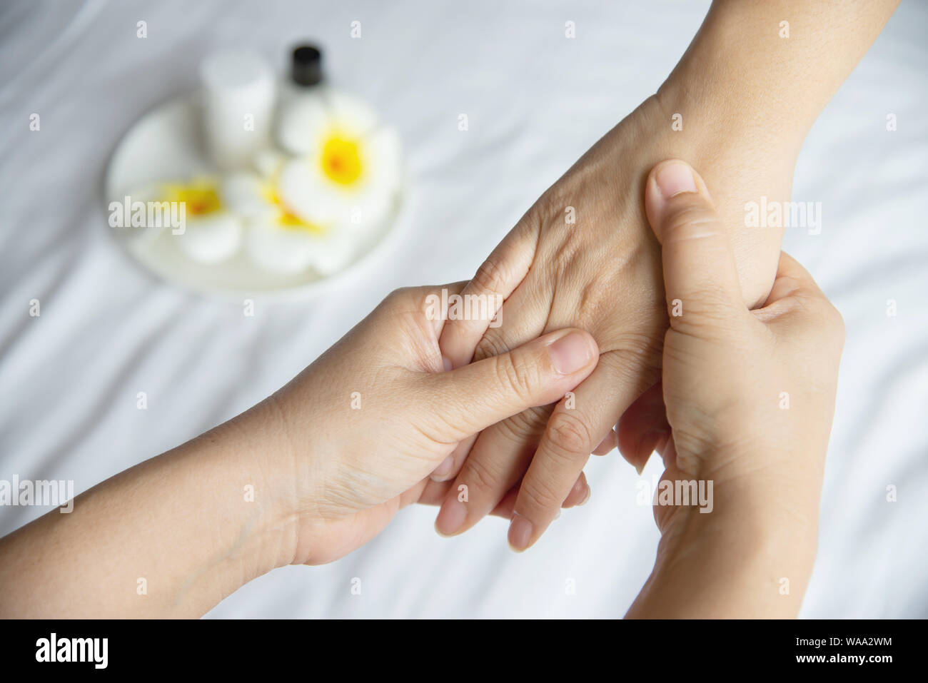 Hand spa massage over clean white bed background - people relax with hand massage service Stock Photo