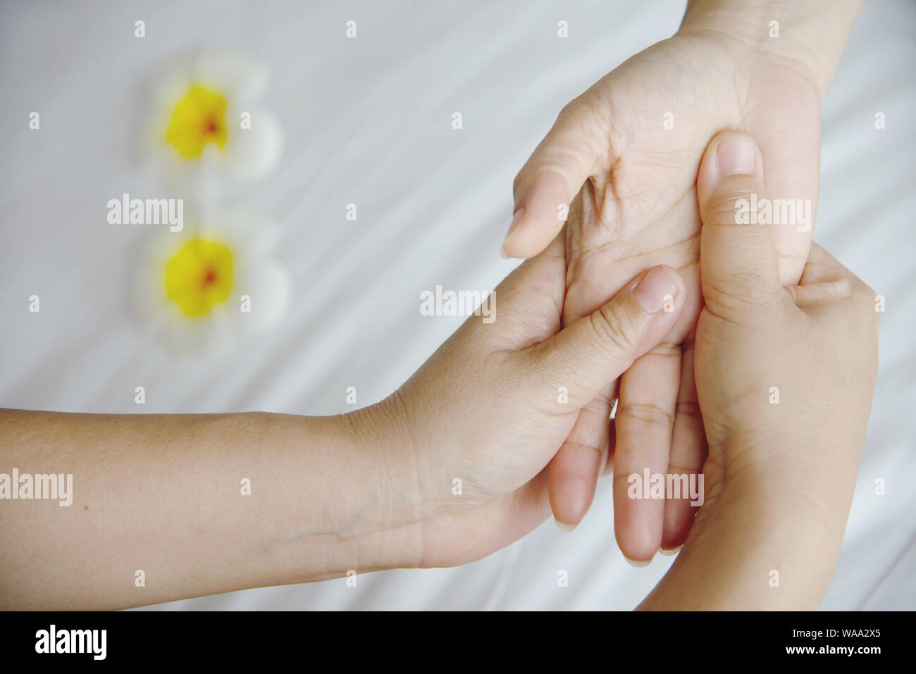 Hand spa massage over clean white bed background - people relax with hand massage service Stock Photo