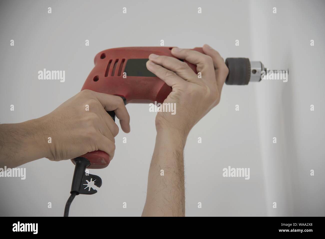 Man using hand drill device for installing home furniture at new white wall people DIY home furniture installation concept Stock Photo Alamy