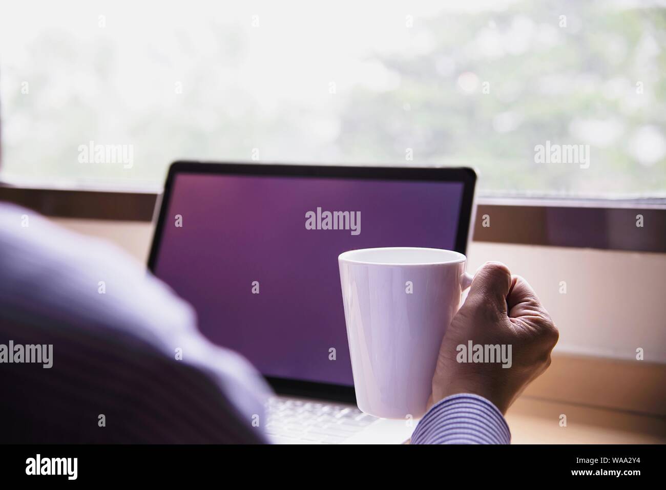 Businessman working with computer with coffee cup in the hotel room - people working lifestyle concept Stock Photo
