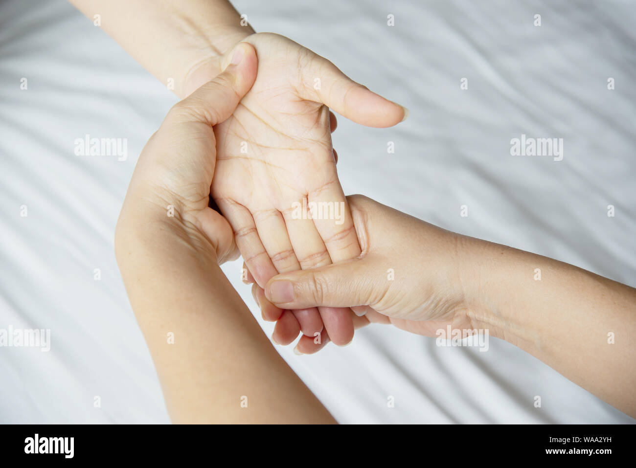 Hand spa massage over clean white bed background - people relax with hand massage service Stock Photo