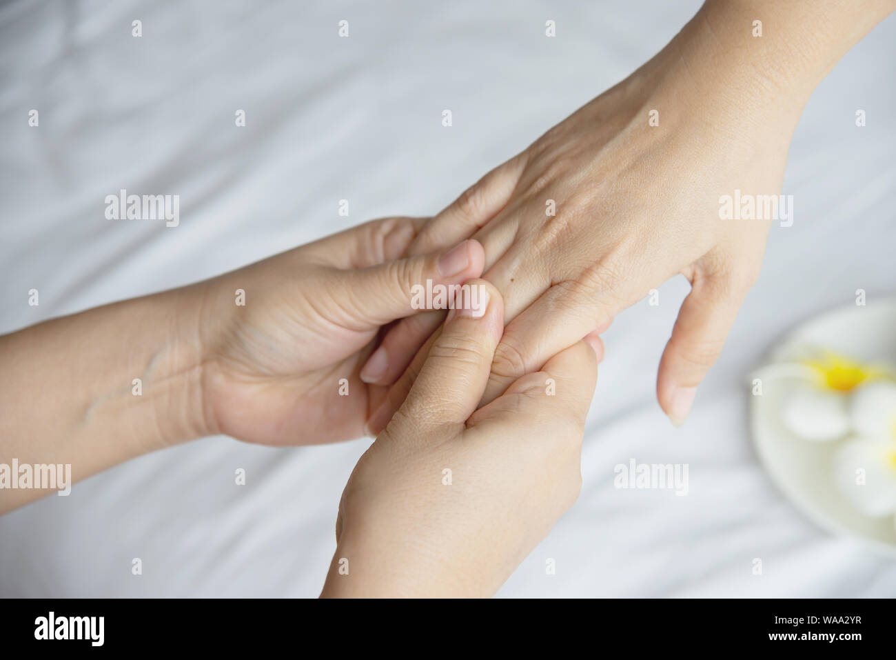 Hand spa massage over clean white bed background - people relax with hand massage service Stock Photo