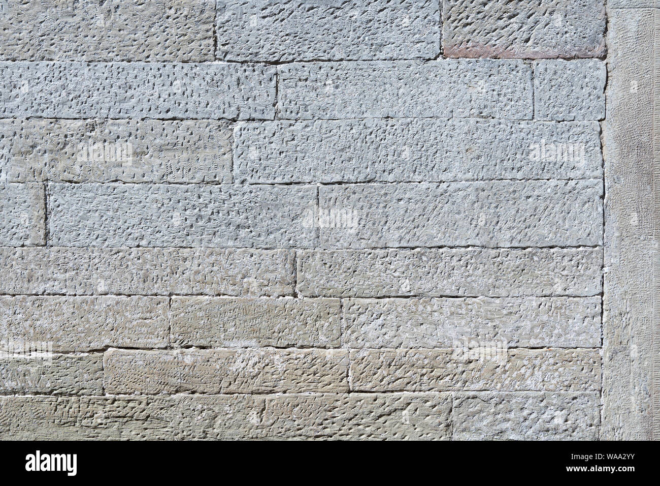 Old stone wall of square elongated stones Stock Photo
