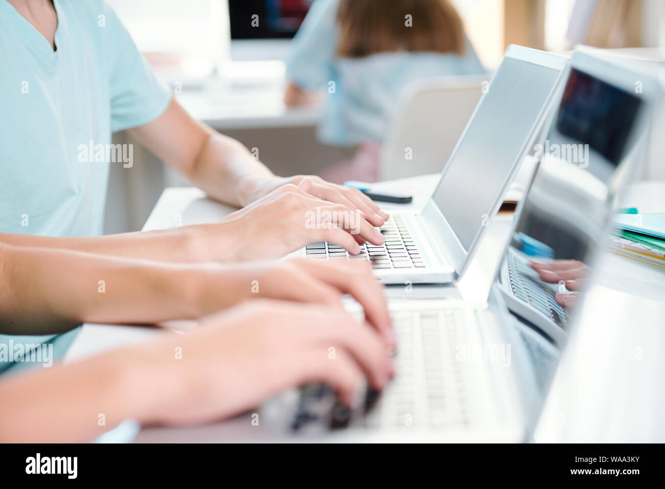 Two contemporary students of school or college typing on laptop keypads Stock Photo