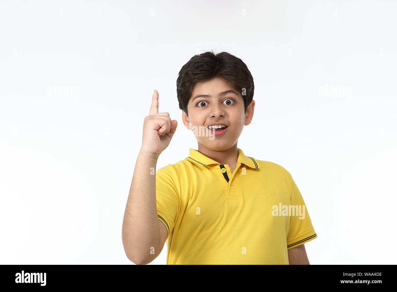 Boy standing and pointing upward Stock Photo
