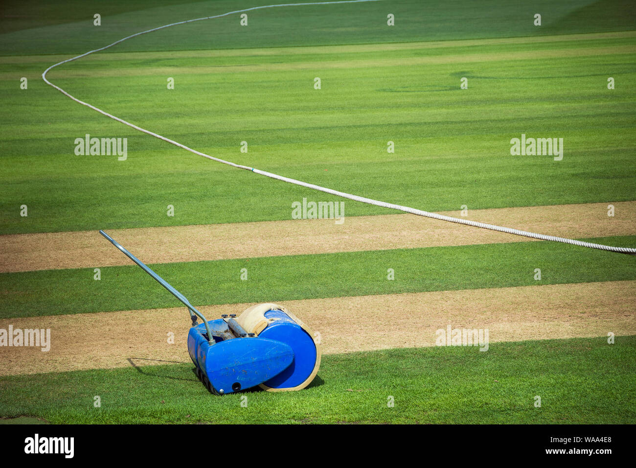 Cricket roller by boundary edge of cricket pitch on sunny day Stock Photo