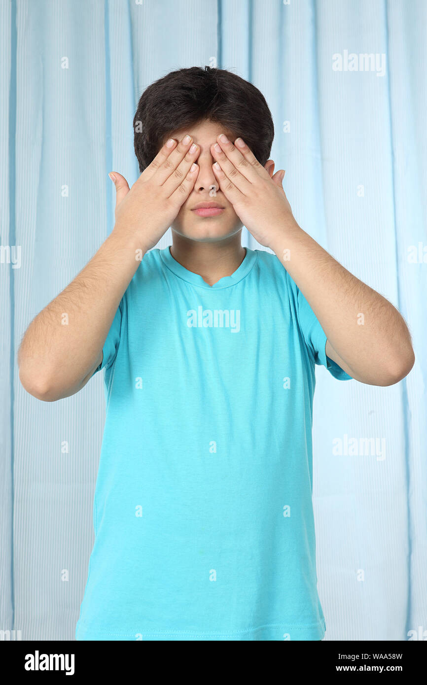Boy covering his eyes with his hands Stock Photo Alamy