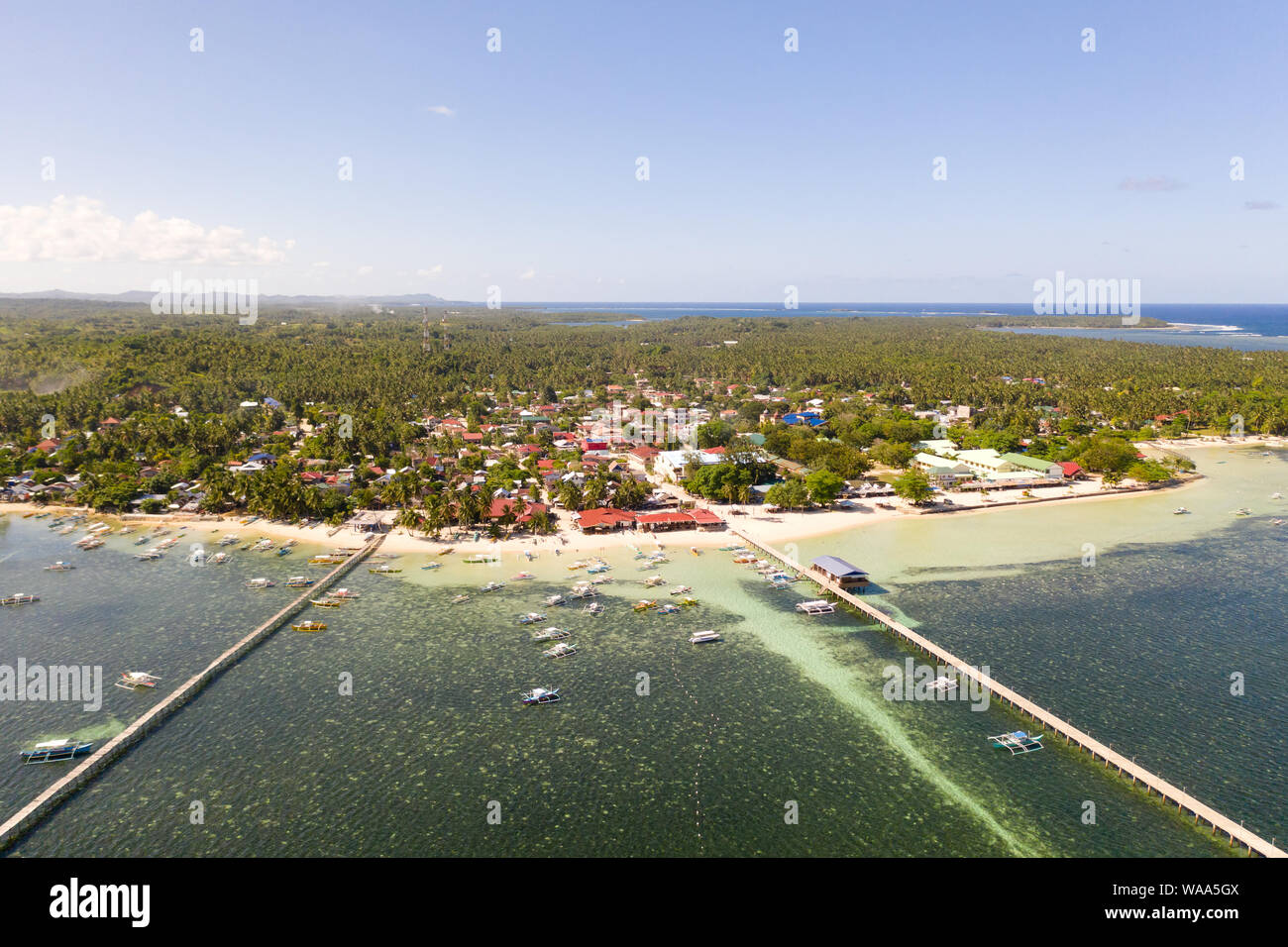 City General Luna on the coast of Siargao with a pier, a port and tourist boats. Marina with boats. Stock Photo