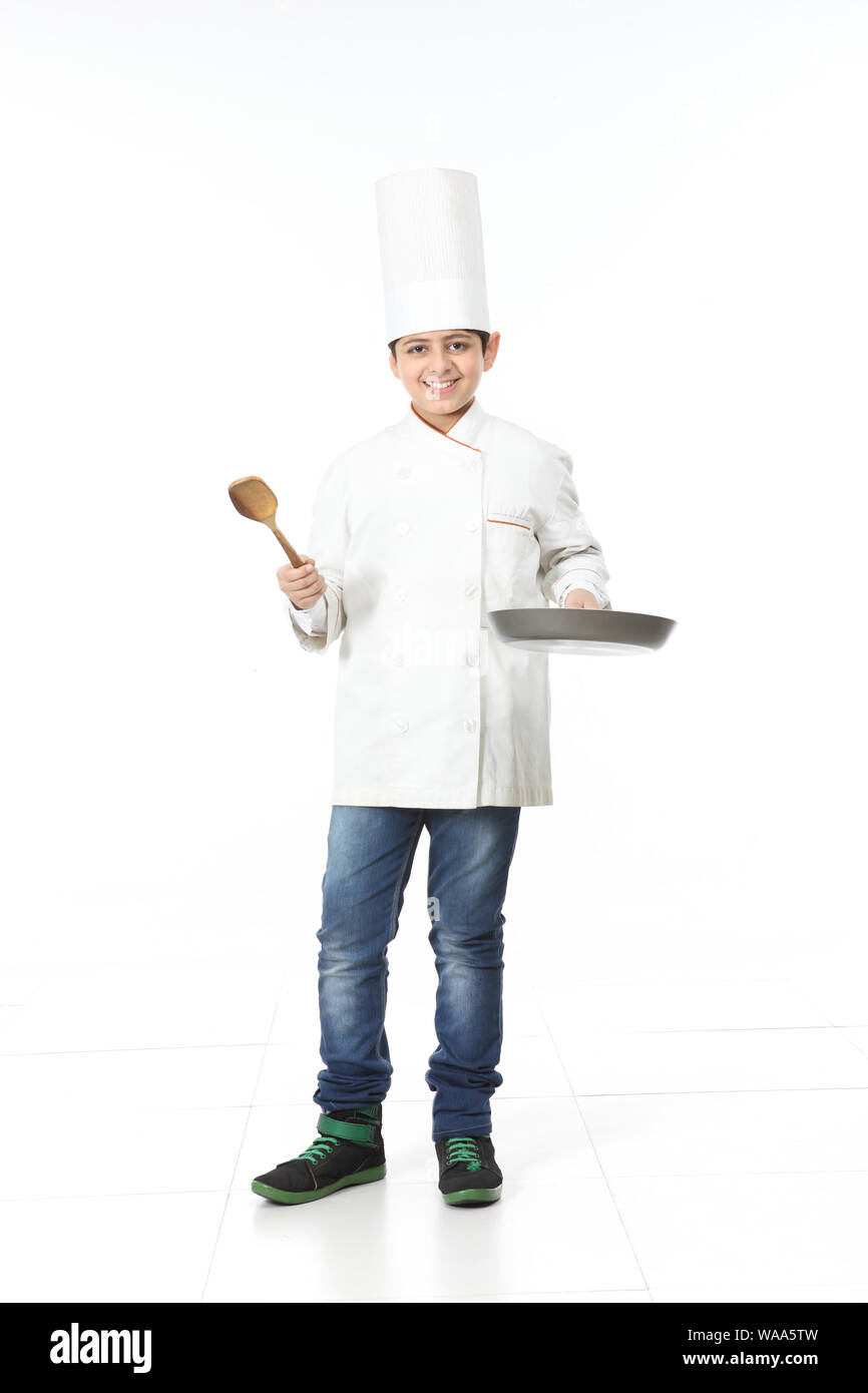 Boy pretending to be a chef and holding frying pan with spatula Stock Photo