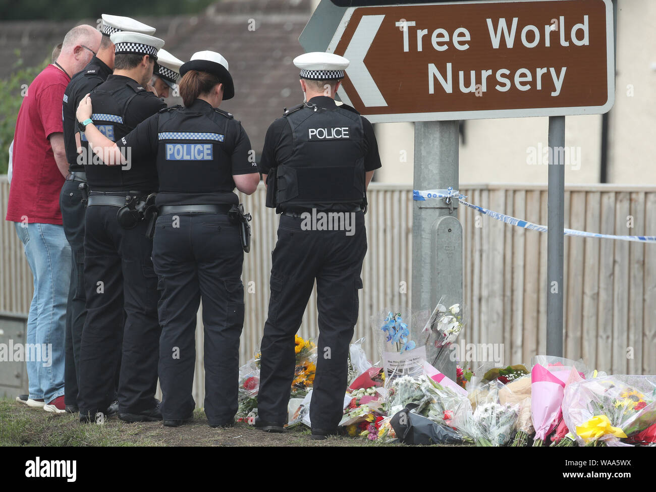 Police officers pay their respects in front of tributes left near Ufton Lane, Sulhamstead, Berkshire, where Thames Valley Police officer Pc Andrew Harper, 28, died following a 'serious incident' at about 11.30pm on Thursday near the A4 Bath Road, between Reading and Newbury, at the village of Sulhamstead in Berkshire. Stock Photo