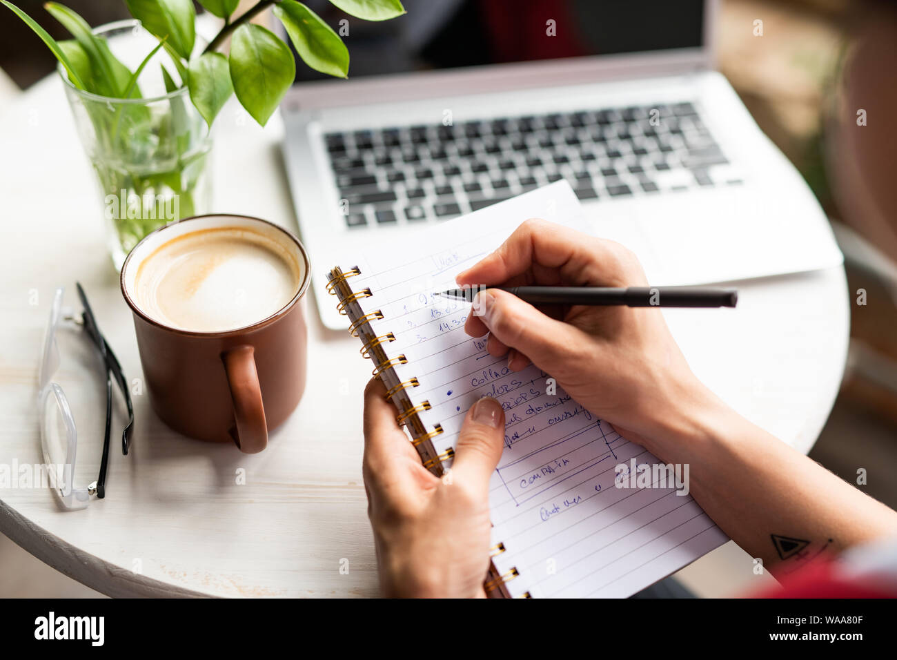 Female hands holding notebook and pen while making working notes by ...