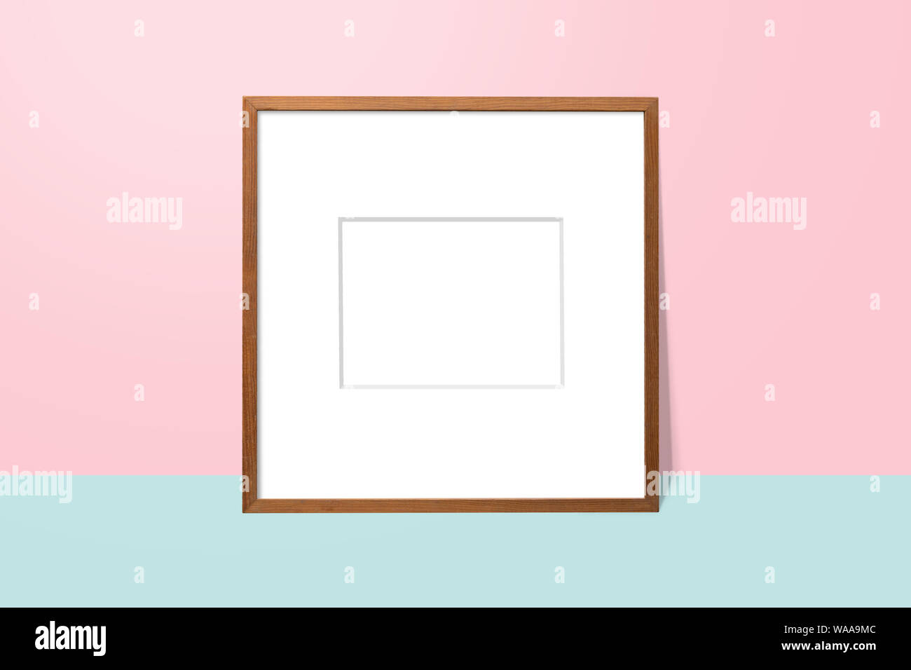 empty white space in wooden blank frame leaning against with pink wall ...