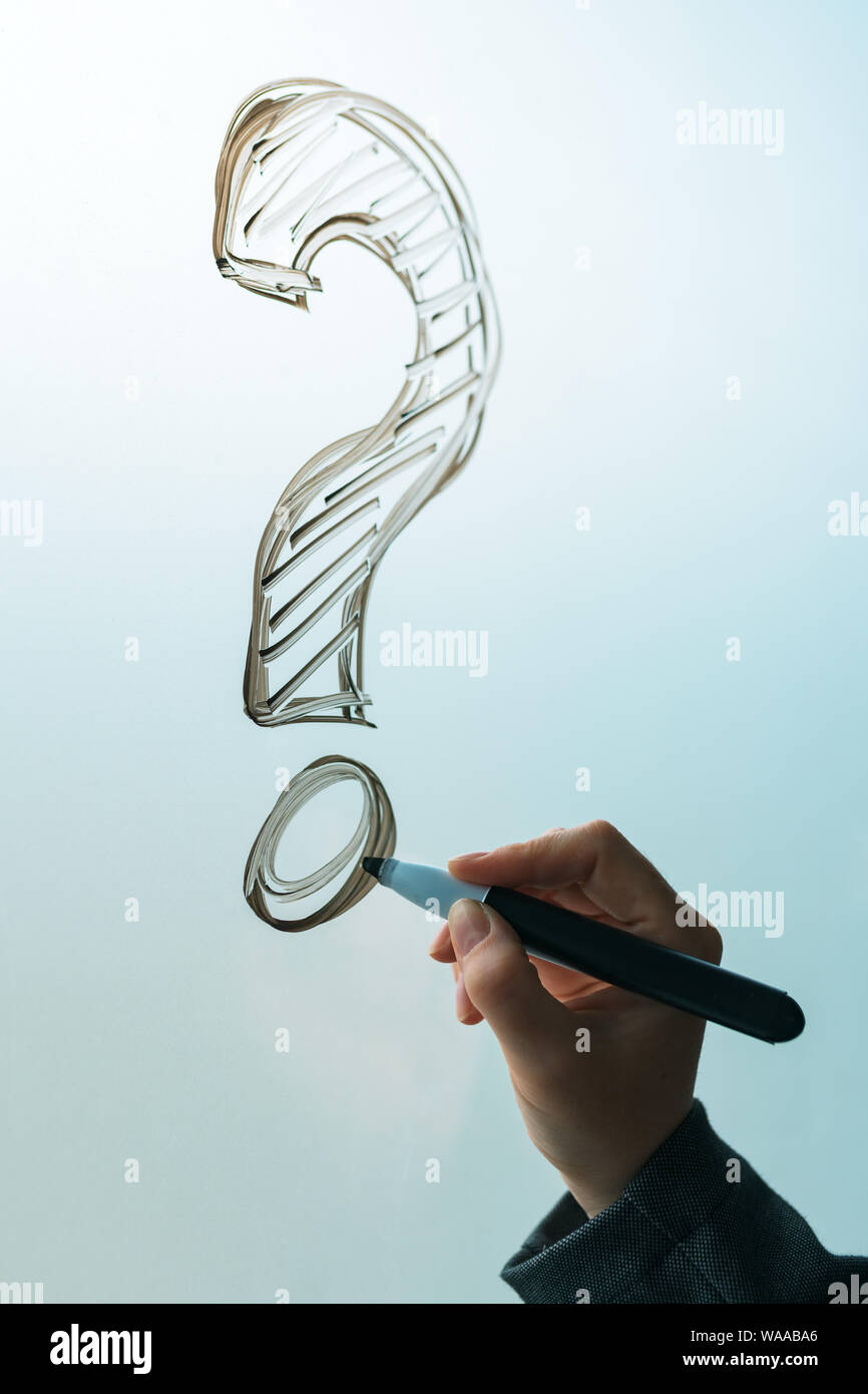 Businesswoman drawing question mark symbol on office whiteboard, close up of hand Stock Photo