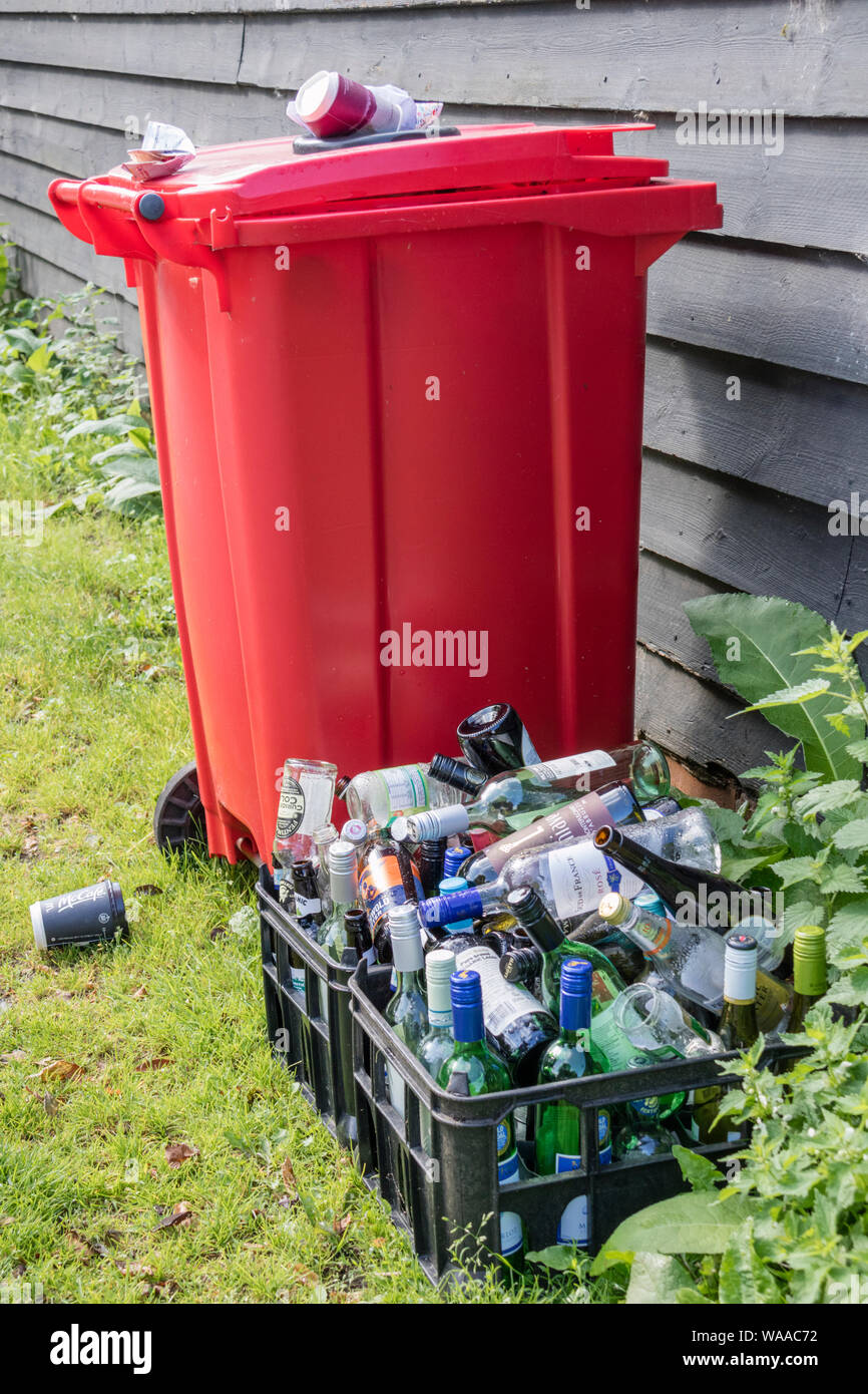 Overfull recycling bin with glass bottles lay Stock Photo - Alamy