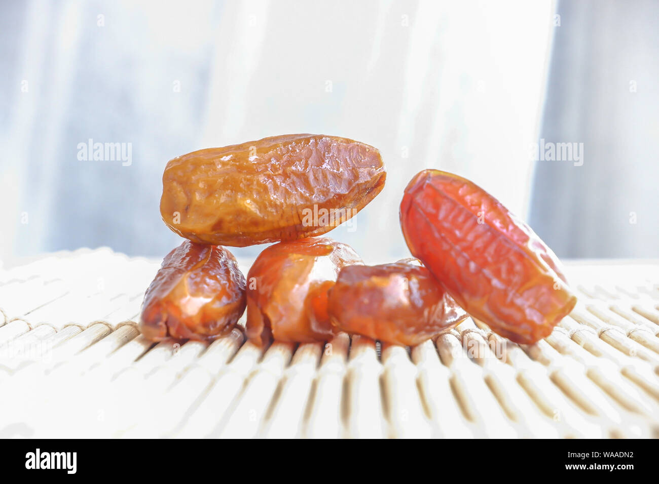 Group of Phoenix fruit on bamboo mat, dried fruits of date palm on bamboo mat background Stock Photo