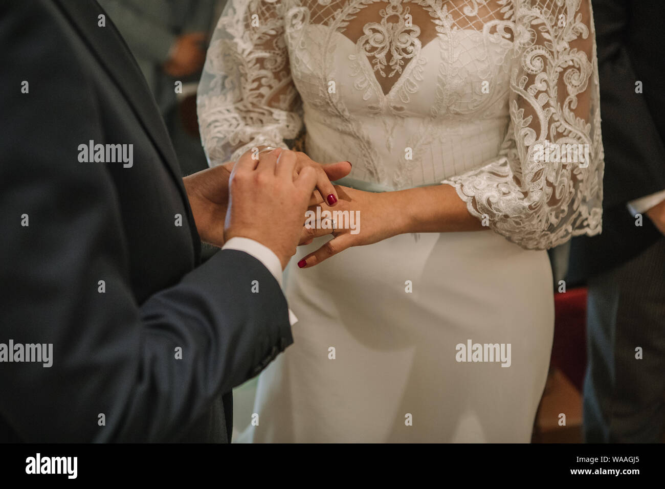 Couple putting on their wedding rings during ceremony Stock Photo Alamy