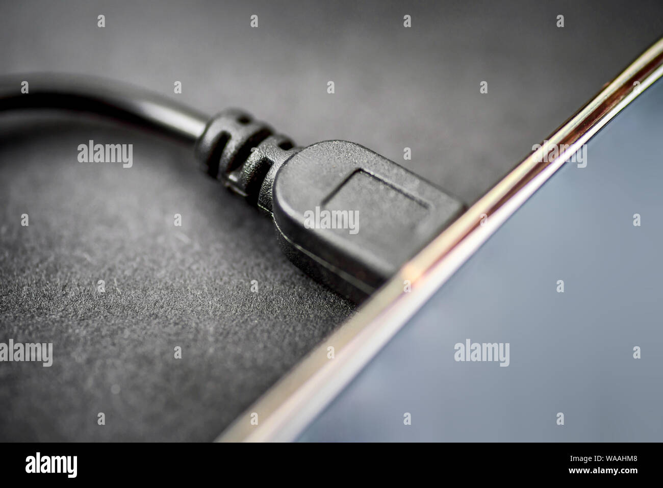 mini usb cable connected to digital tablet closeup view Stock Photo
