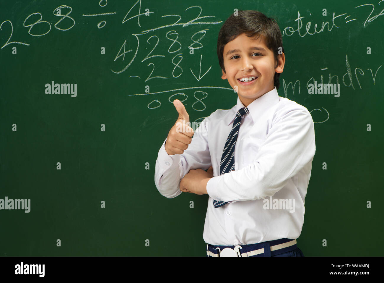 Schoolboy standing and showing thumbs up sign in a classroom Stock ...