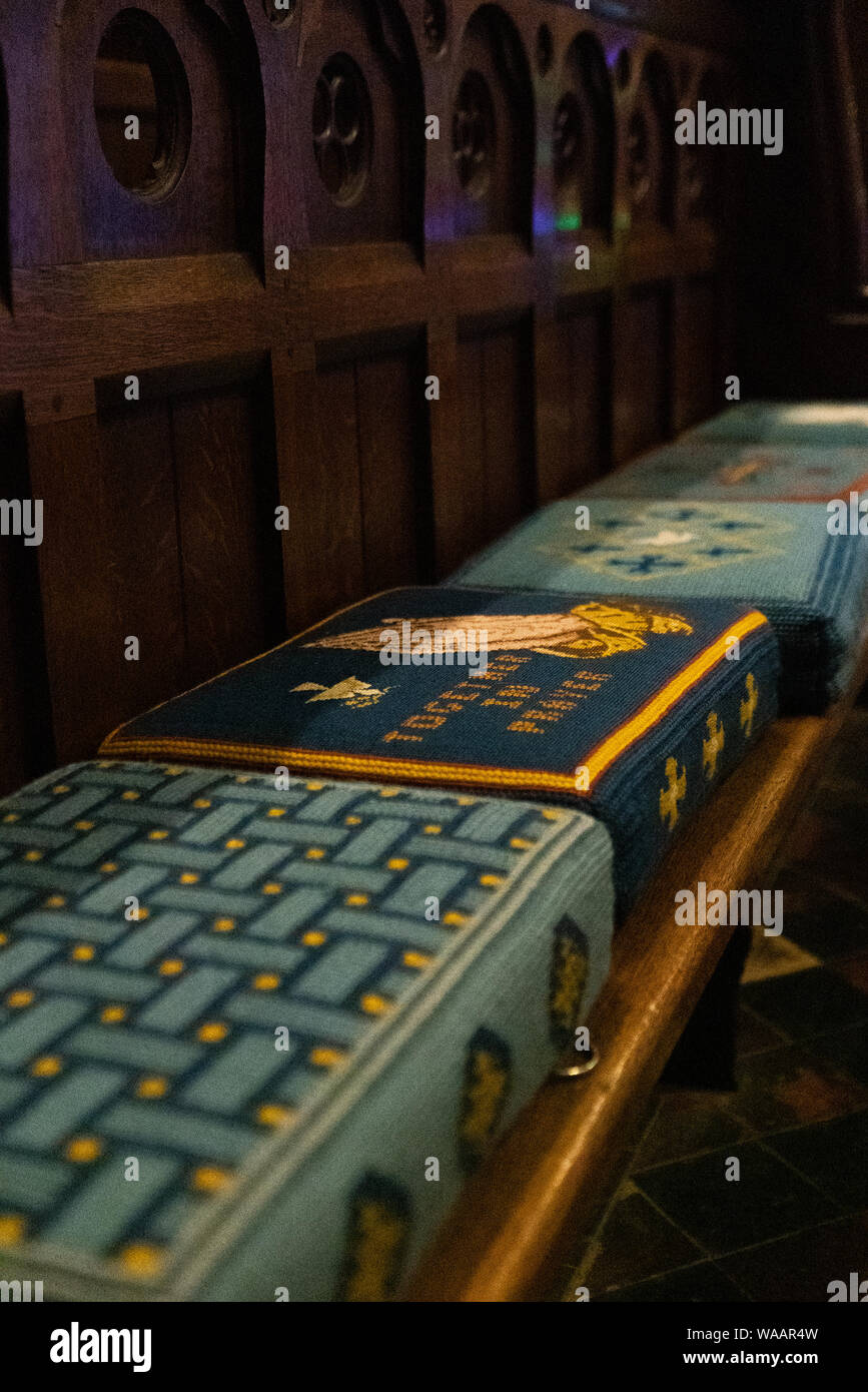 Tapestried pew cushions in a traditional old church, England, UK. Church of England churches. Stock Photo