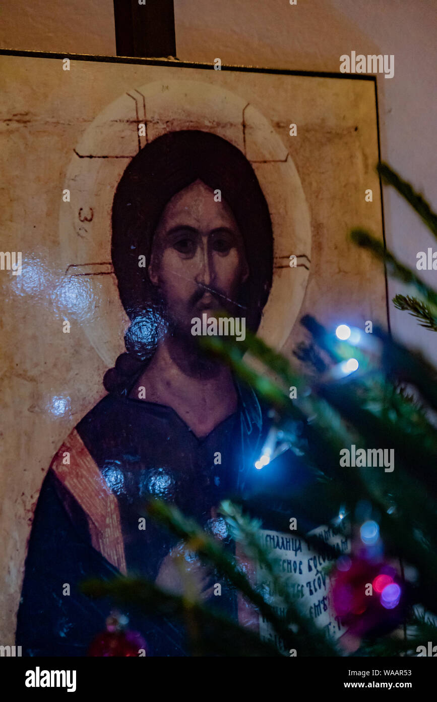 An icon of Christ set behind a decorated Christmas tree in a traditional church building, England, UK. Church of England churches. Stock Photo