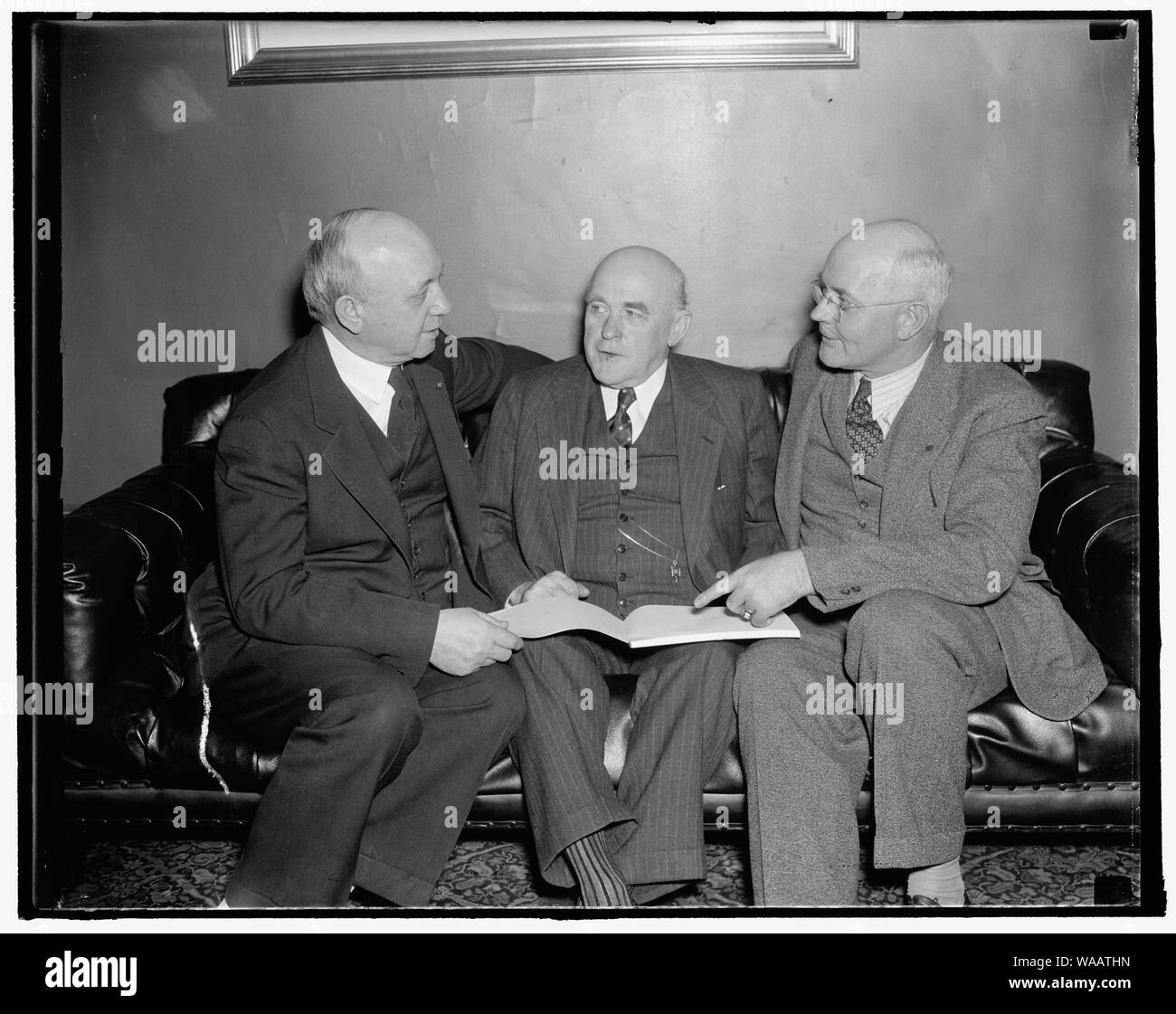 Co-authors discuss amendments to farm bill with Alabama senator. Washington, D.C., Nov. 30. Co-authors of the Senate Farm Bill, Senators George McGill of Kansas, (left) and Senator James P. Pope of Idaho, (right) discuss amendments to the bill now being written by Senator John B. Bankhead (center) of Alabama. Senator Bankhead has appealed to the Senate for enactment of the strongly compulsory cotton section of the bill to prevent disastrous fluctuations in the price of cotton which he said were 'threatening foreclosures all over the South. 11/30/37 Stock Photo