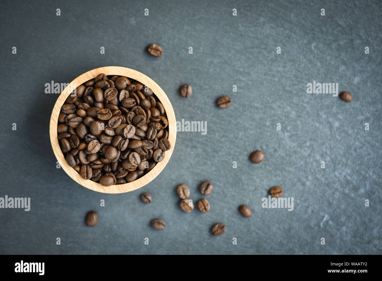 Roasted coffee beans on wooden bowl and dark background Stock Photo - Alamy