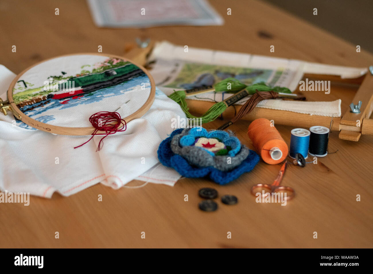 Crossstitch embroidery materials, including threads, needles, scissors, linen and hoops. laid