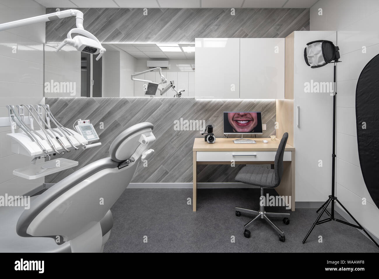 in a dental clinic with light walls and dark gray floor. There
