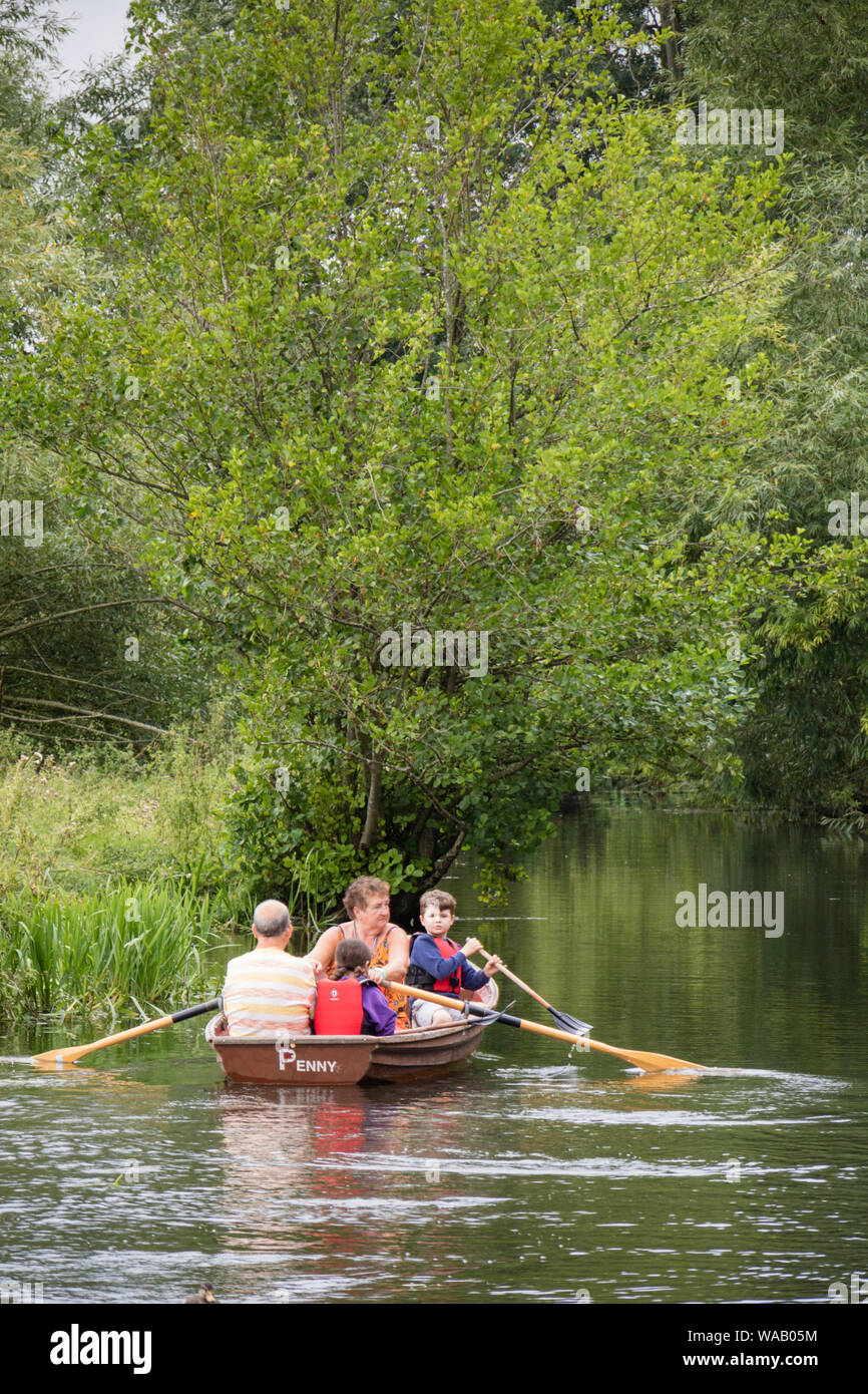 Visitors to Flatford Mill hire rowing boats to explore the River Stour, Dedham Vale, Suffolk, England, UK Stock Photo
