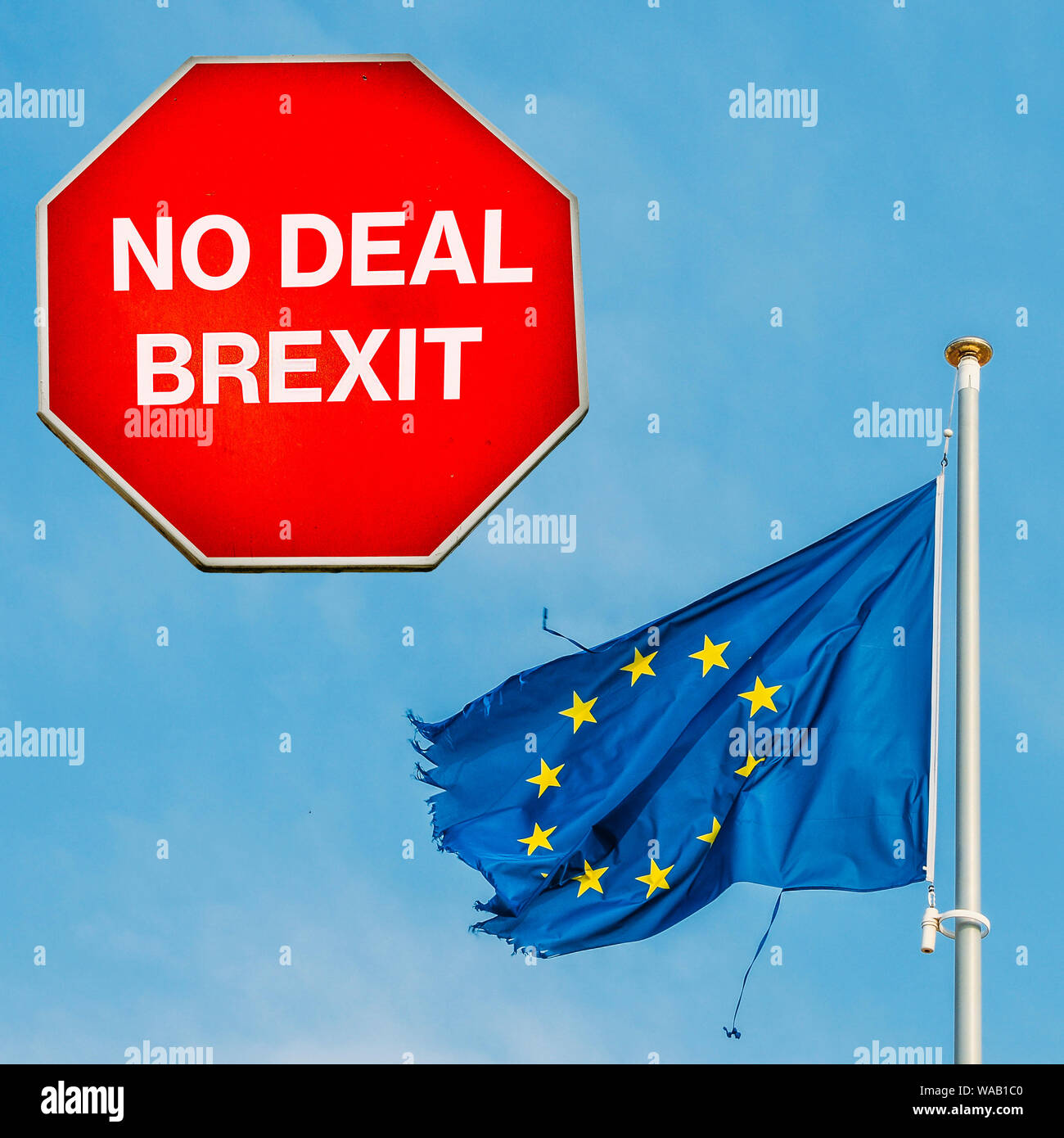 No Deal Brexit written on octagon stop sign with ripped EU flag on background. UK is set to leave the EU on October 31st, 2019 Stock Photo