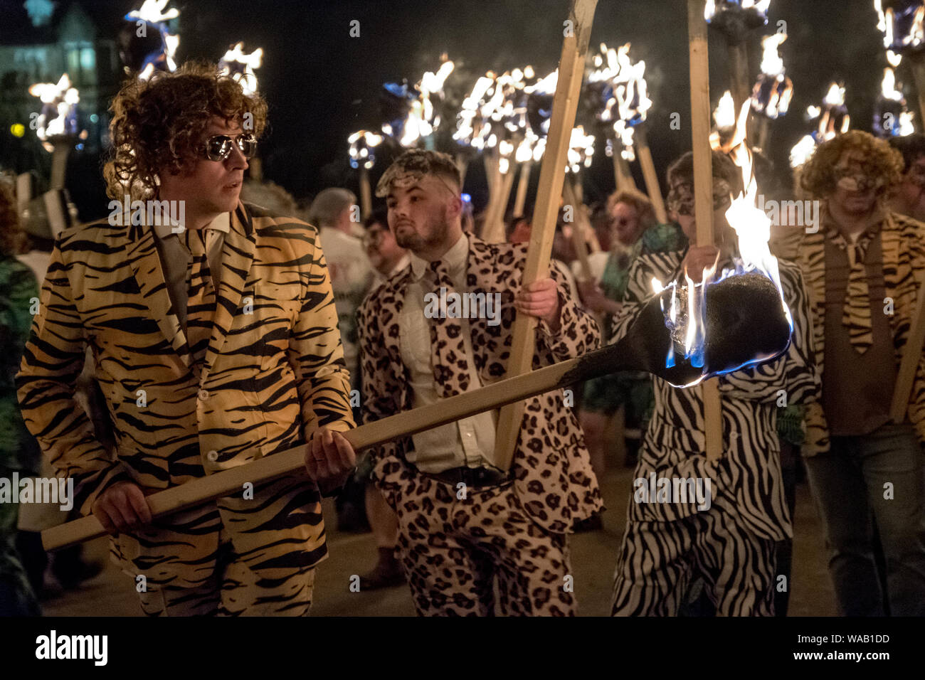 Men in animal print costumes carry fire torches as part of the 2019 Up Helly Aa night procession in Lerwick, Shetland Stock Photo