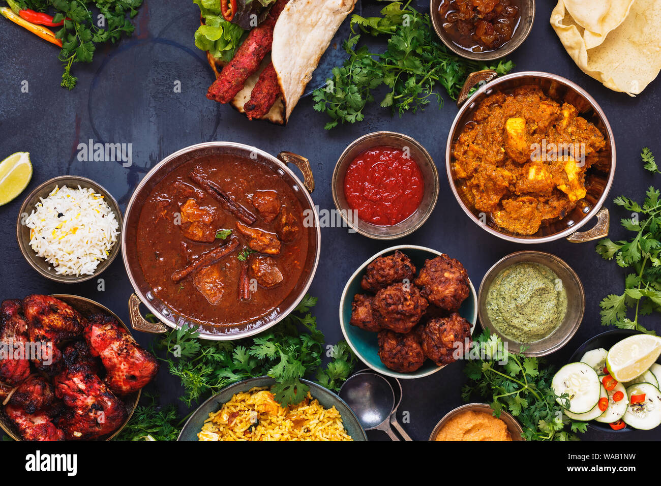 Taste of India. A selection of Indian food with various bowls of food featuring  chicken tikka masala, rogan josh, kebabs, tandoori chicken wings, pas Stock Photo