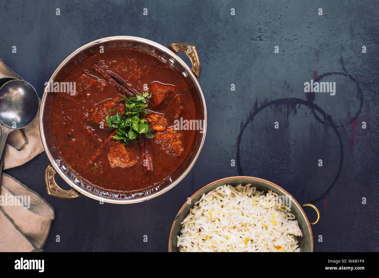 Kashmiri Lamb Rogan Josh. Slow cooked lamb curry served with pulao rice and garnished with coriander. Top view, blank space Stock Photo