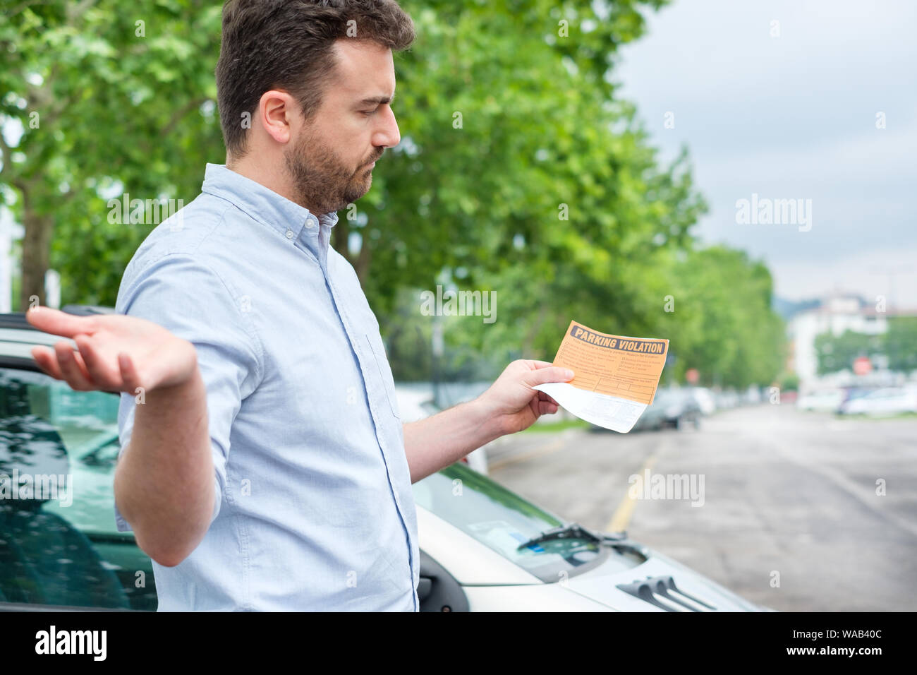 Angry man finds parking ticket after parking time limit expired Stock