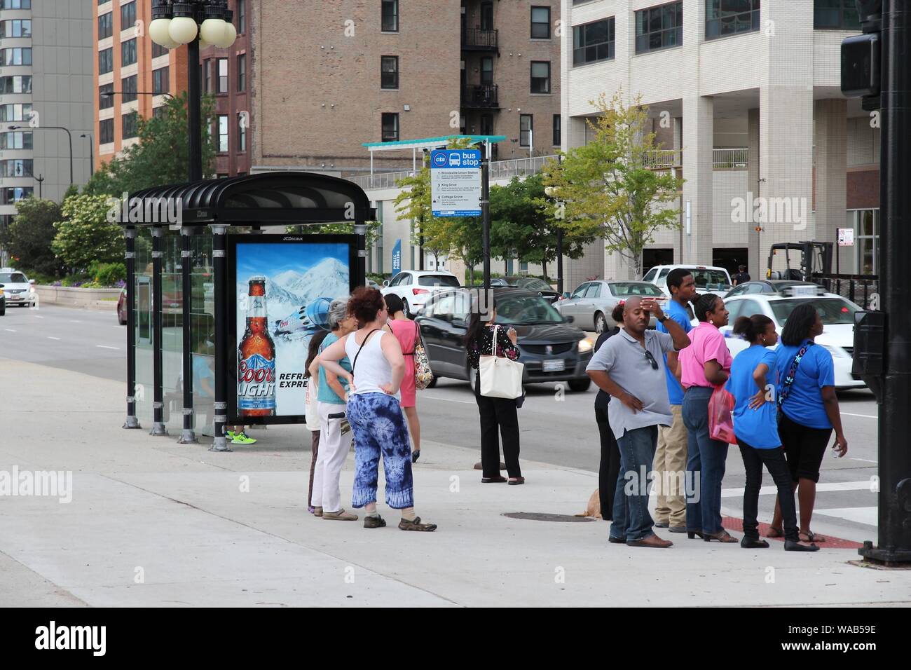 CHICAGO, USA - JUNE 27, 2013: People wait at a bus stop in Chicago. Chicago is the 3rd most populous US city with 2.7 million residents (8.7 million i Stock Photo