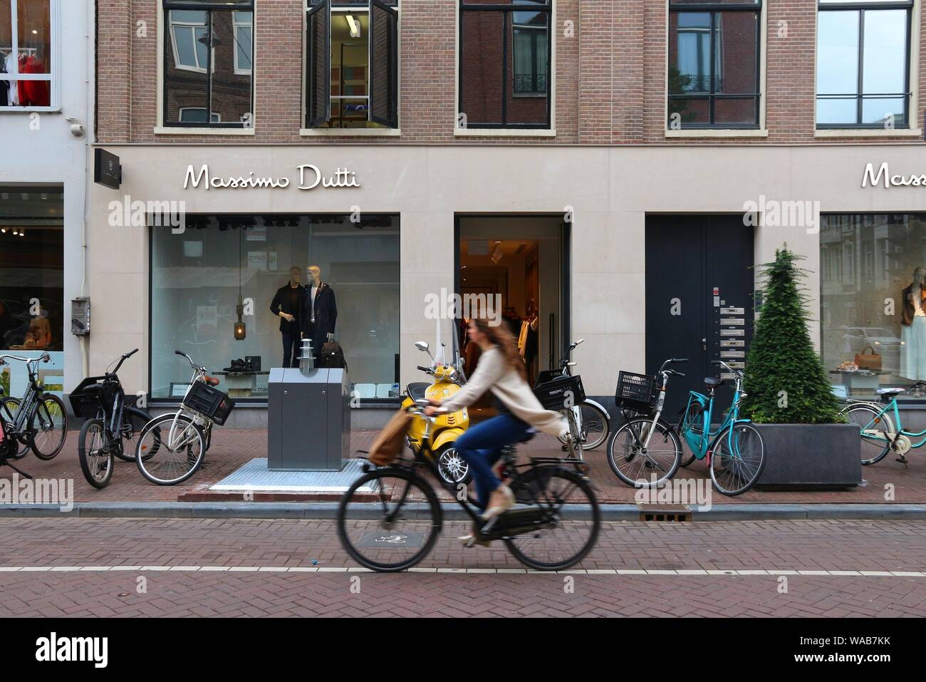 AMSTERDAM, NETHERLANDS - JULY 10, 2017: Cyclist rides by Massimo Dutti  fashion shop at P.C. Hooftstraat in Amsterdam. Pieter Cornelis Hooftstraat  is t Stock Photo - Alamy