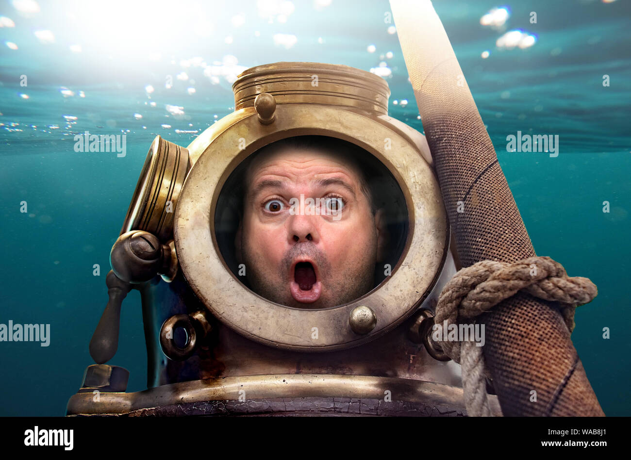 Portrait of man in old diving suit and helmet under water. Funny