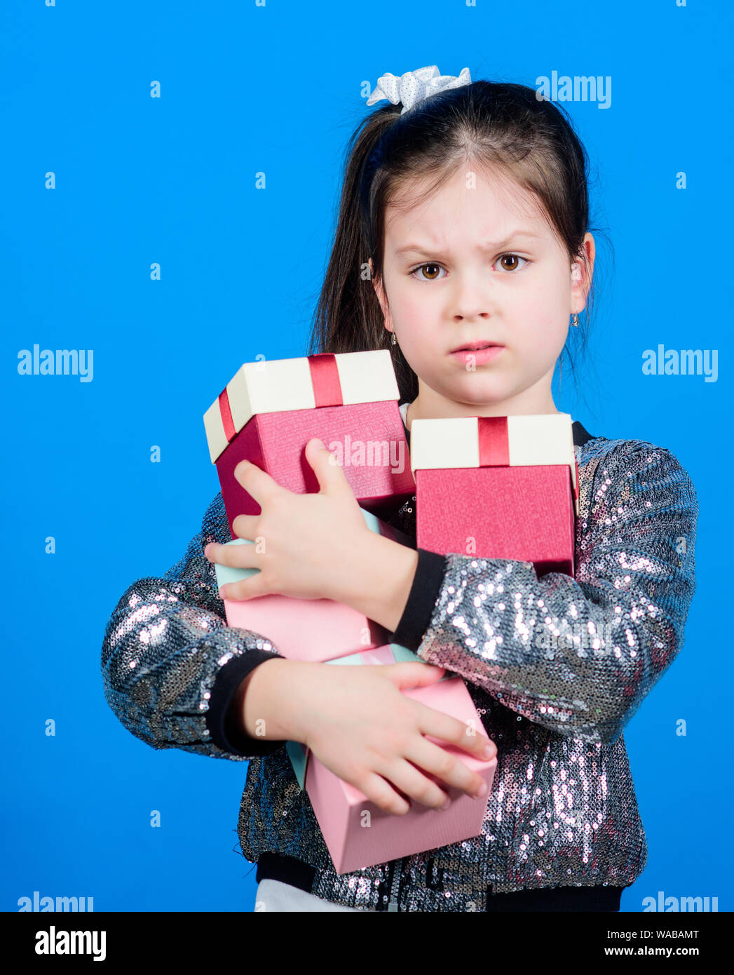 Girl with gift boxes blue background. Black friday. Shopping day. Child carry lot gift boxes. Surprise gift box. Birthday wish list. World of happiness. Only for me. Special happens every day. Stock Photo