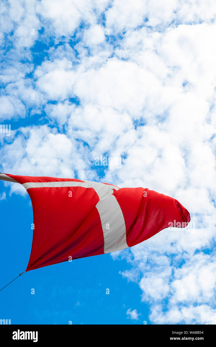 Flag of Denmark, Dannebrog against the blue sky develops in the wind Stock Photo