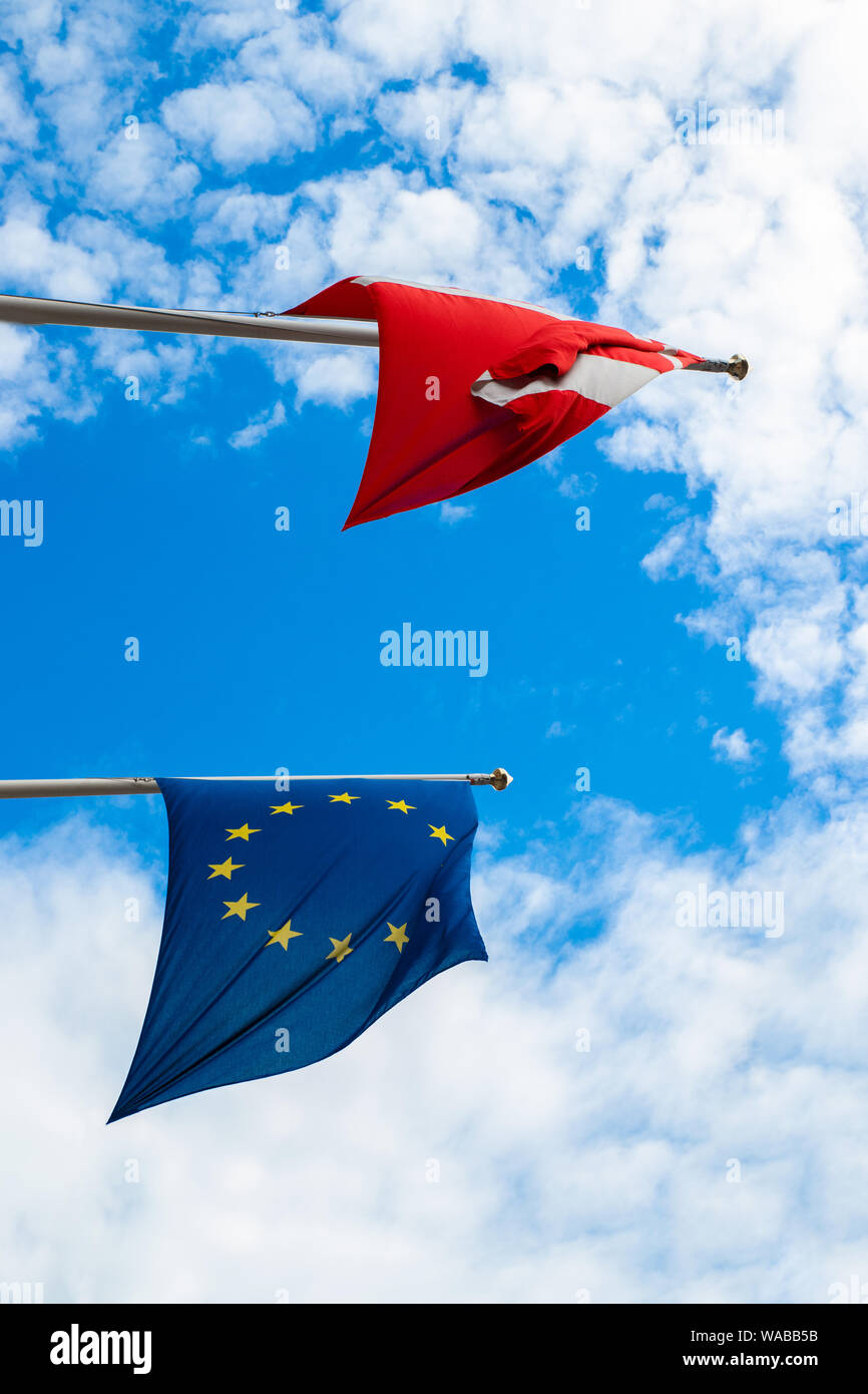 The flag of Denmark and the European Union against a blue sky develops in the wind Stock Photo