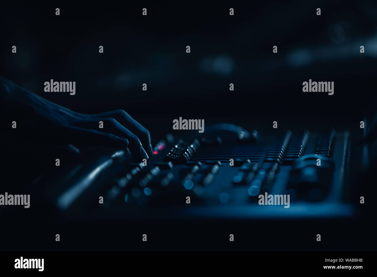 Professional stage lighting technician control lights on rock concert