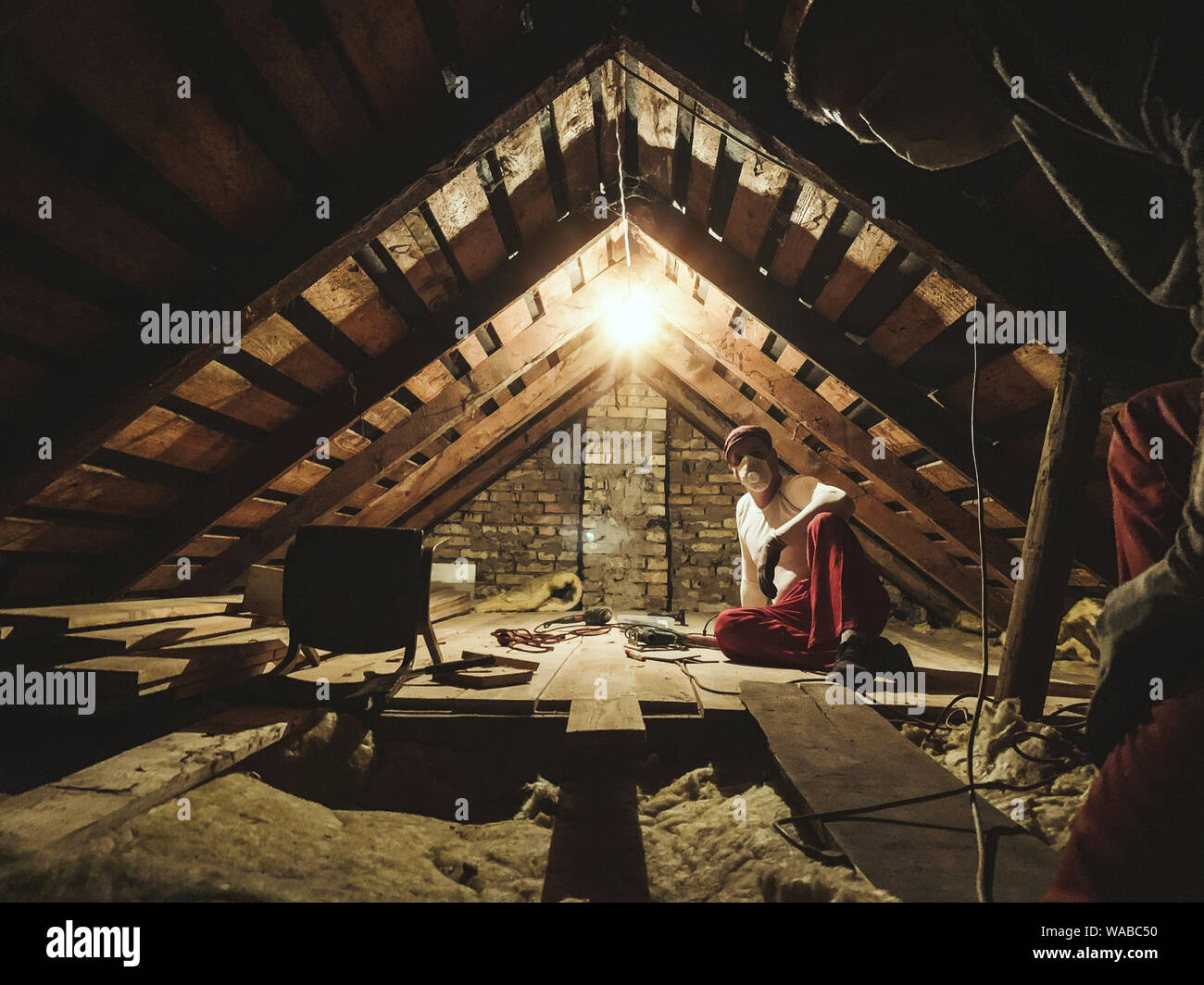 Two man repair old garret at house Stock Photo - Alamy