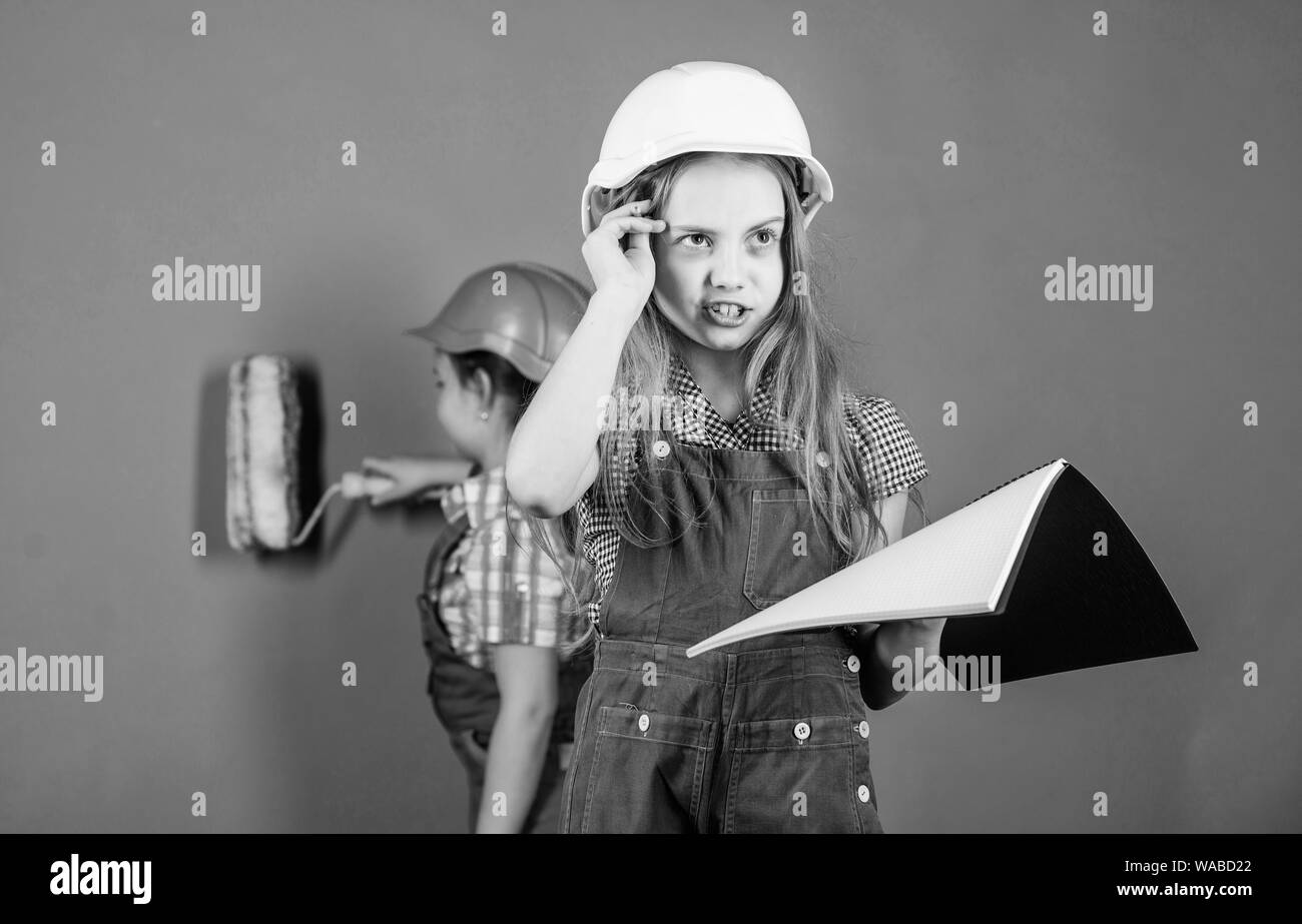 Home improvement activity. Kids girls planning renovation. Repaint walls. Move in new apartment. Children sisters run renovation their room. Control renovation process. Sisters happy renovating home. Stock Photo