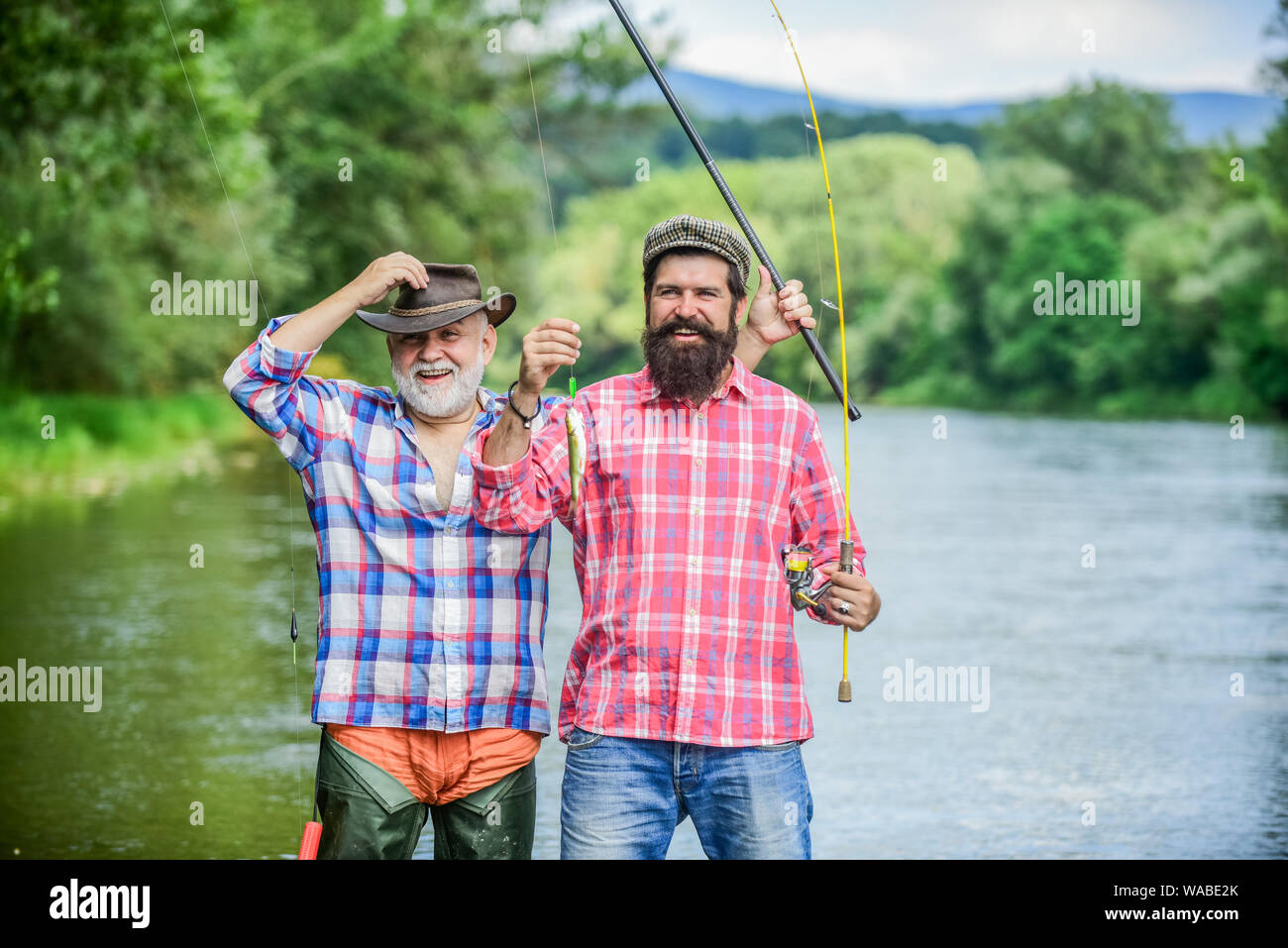 Fisherman with fishing rod. Activity and hobby. Fishing freshwater lake  pond river. Bearded men catching fish. Mature man with friend fishing.  Summer vacation. Happy cheerful people. Family time Stock Photo - Alamy