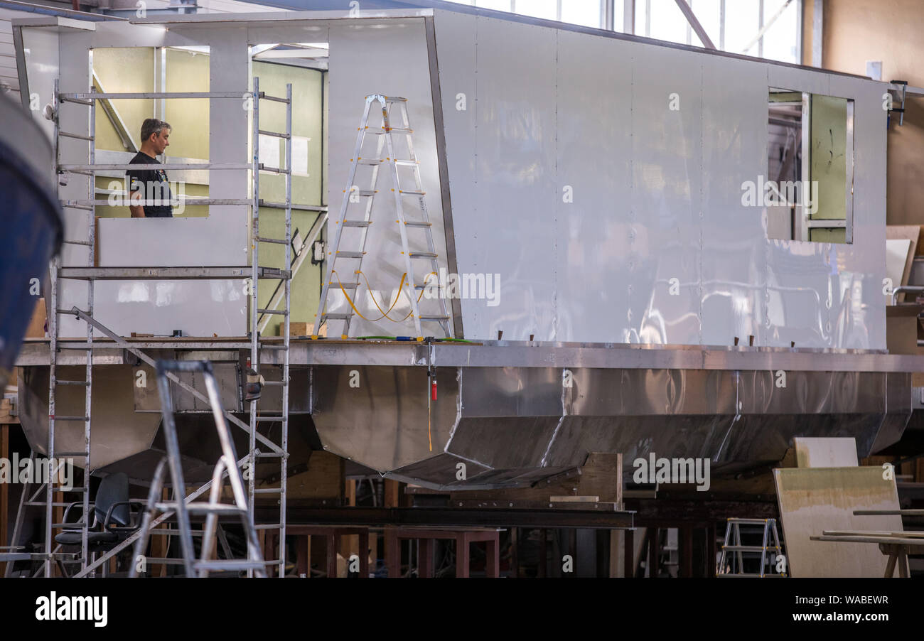 Rechlin, Germany. 25th May, 2019. A houseboat is overhauled in the Kuhnle shipyard shipbuilding hall. The boats intended for charter tours on the Mecklenburg Lake District can also be driven by holidaymakers without a boat driving licence. Equipped with a steel hull and bow thruster, the boats are up to 15 metres long and have up to four cabins. Credit: Jens Büttner/dpa-Zentralbild/ZB/dpa/Alamy Live News Stock Photo