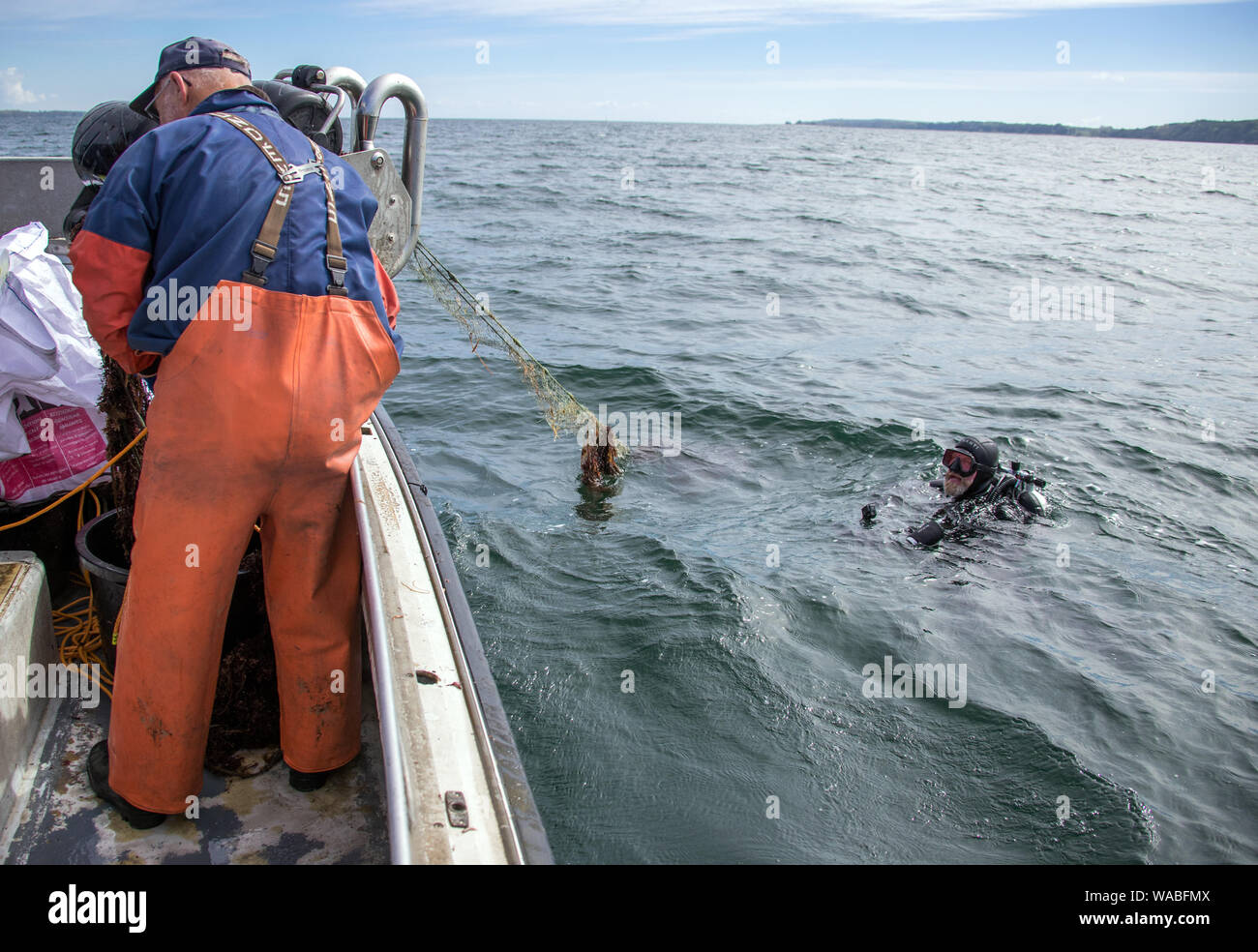 15 May 2019, Schleswig-Holstein, Eckernförde: Divers document beside the  fishing cutter Ecke20 the recovery of a ghost net from the Baltic Sea.  Every year thousands of fishing nets land in the North